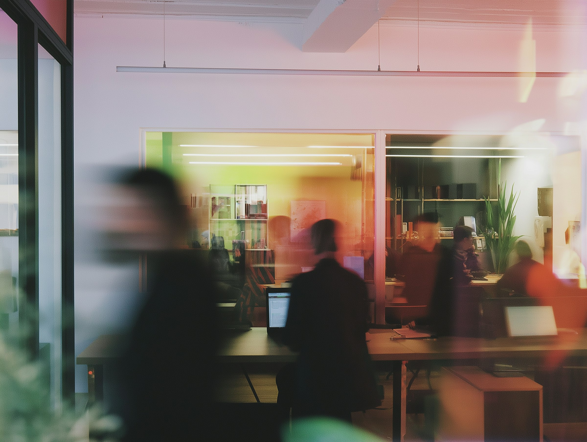 Unlocking Sales Growth: A blurred, colorful image shows people moving through a modern office space with glass walls, desks, and computers